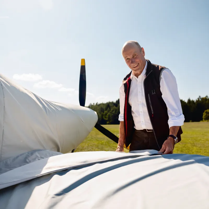 Uli Schwenk beim Anbringen eines passgenauen Jaxida Schutzbezugs am Flugzeug
