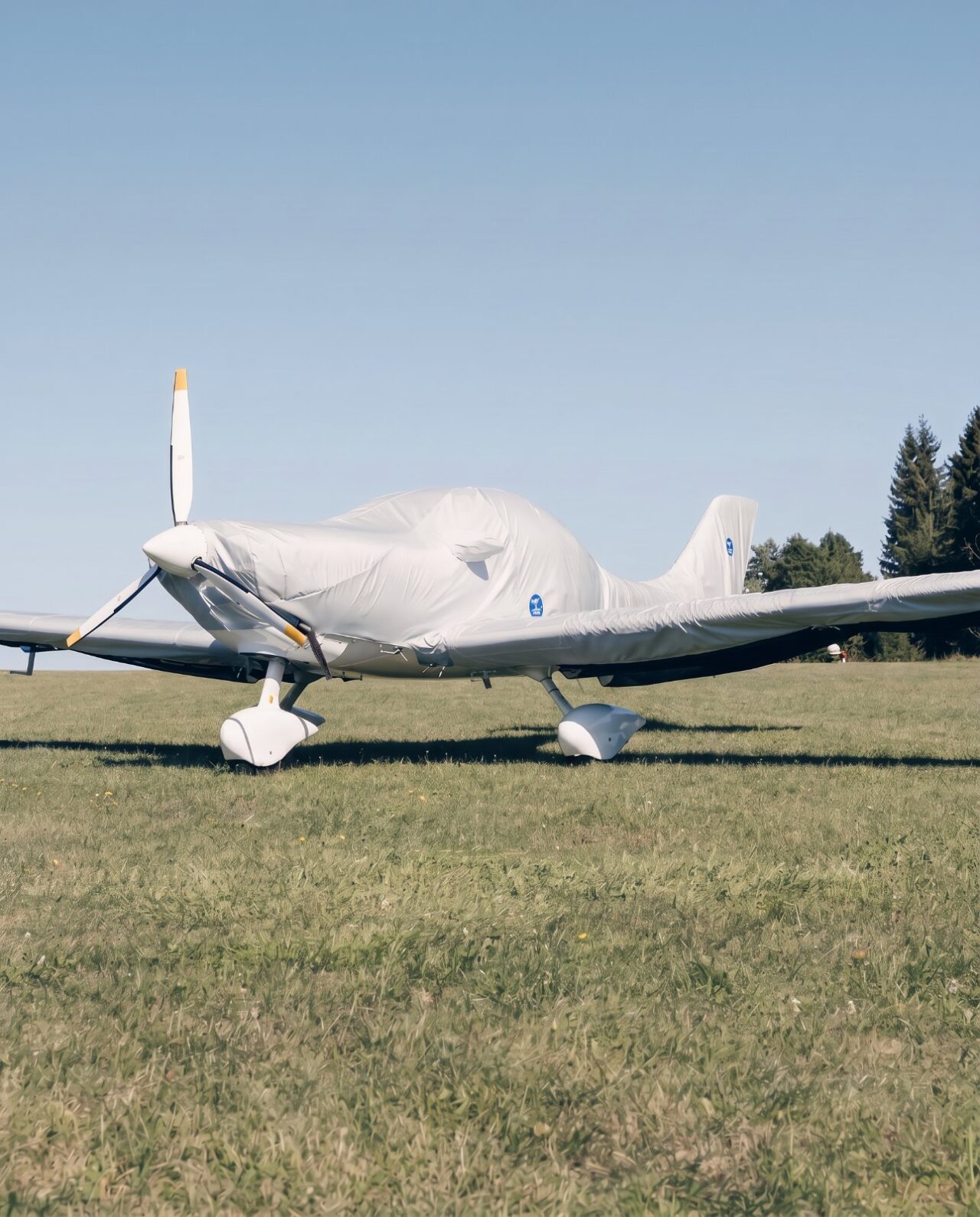 Ultraleichtflugzeug mit maßgeschneidertem Jaxida Schutzbezug auf einer Grasfläche