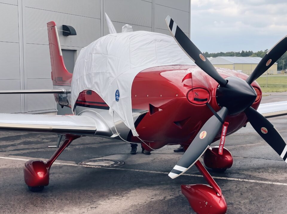 Rotes Motorflugzeug mit passgenauer Jaxida Schutzabdeckung für Cockpit und Rumpf