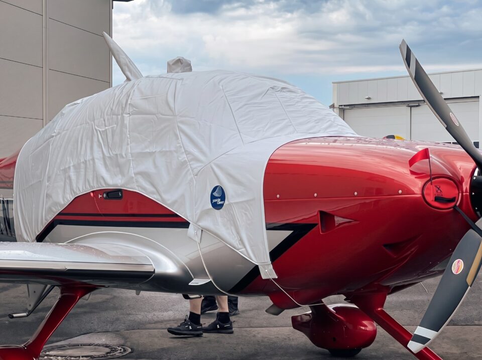 Rotes Motorflugzeug mit maßgeschneidertem Jaxida Allwetter-Schutzbezug