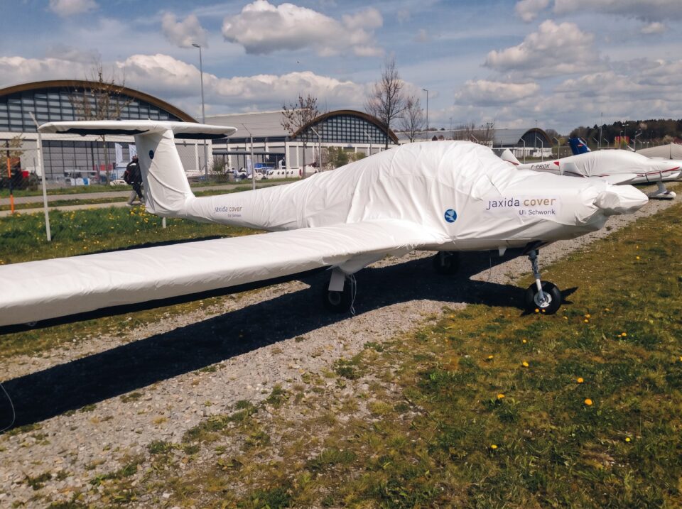 Motorflugzeug mit maßgeschneidertem Jaxida Schutzbezug auf dem Vorfeld