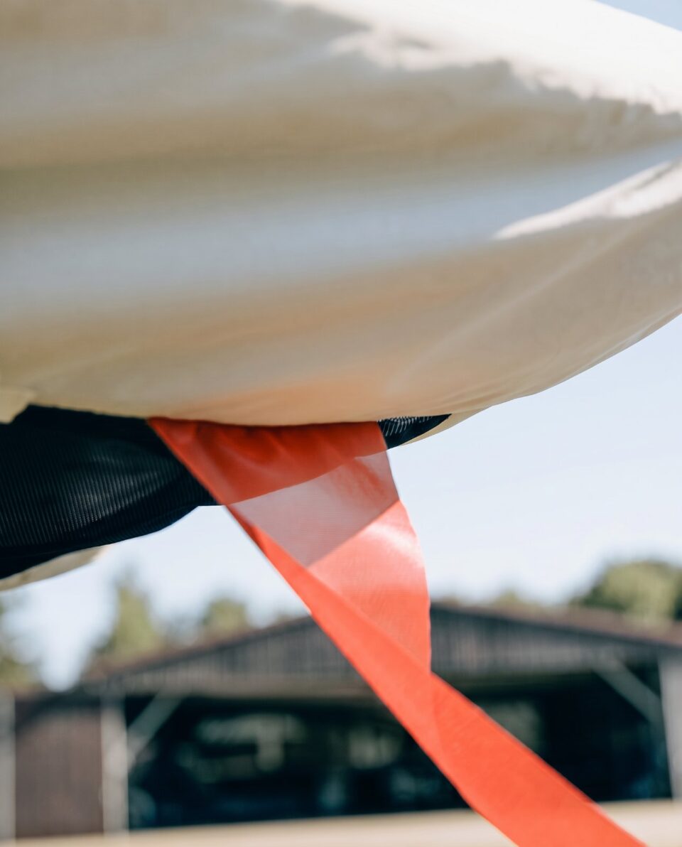 Detailaufnahme eines Jaxida Flugzeugcovers mit orangefarbendem Befestigungsgurt