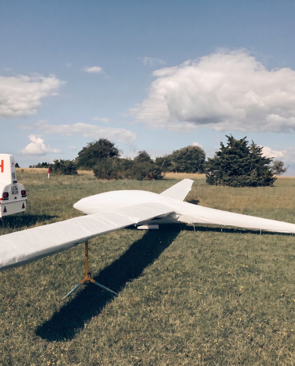 Segelflugzeug mit maßgeschneidertem Jaxida Cover auf einer Grasfläche
