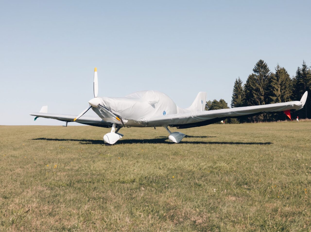 Ultraleichtflugzeug mit komplettem Jaxida Flugzeug-Cover auf einer Grasfläche