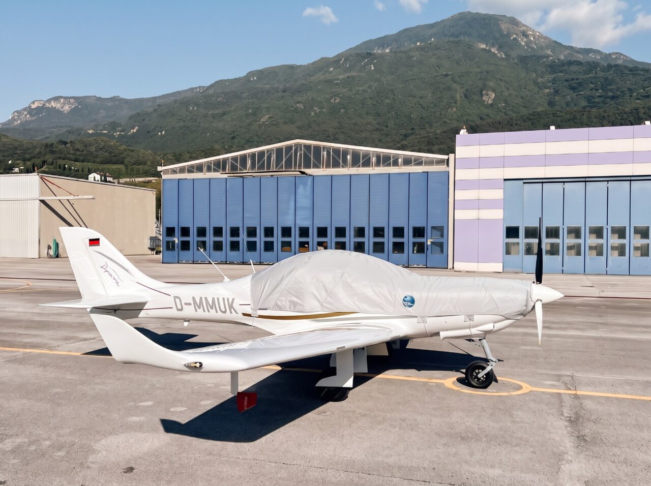 Ultraleichtflugzeug mit maßgeschneidertem Jaxida Schutzbezug vor einem Hangar